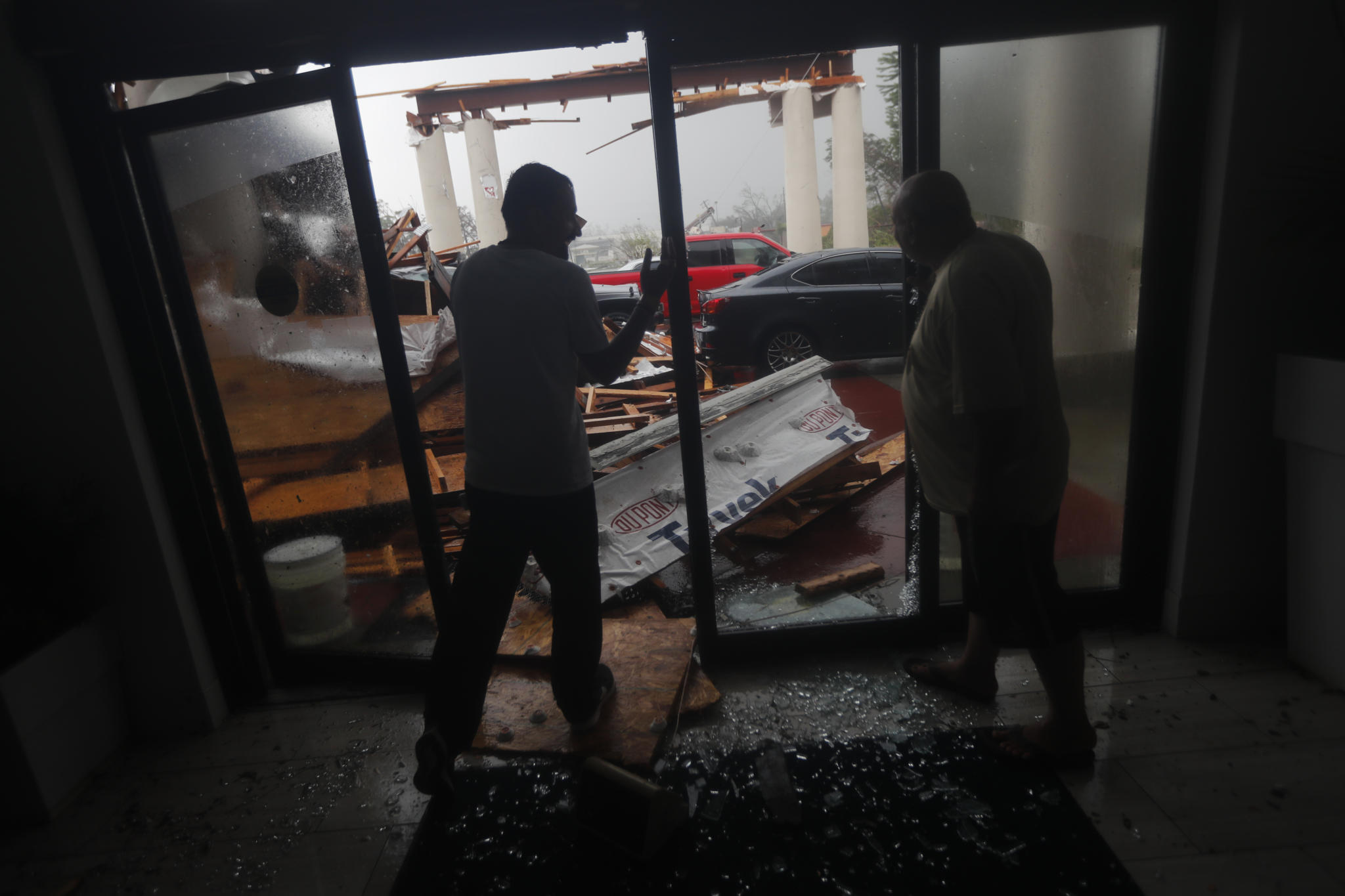 Hotel employees look at a canopy that just collapsed, as Hurricane Michael passes through in Panama City Beach, Fla., Wednesday, Oct. 10, 2018. (AP Photo/Gerald Herbert)