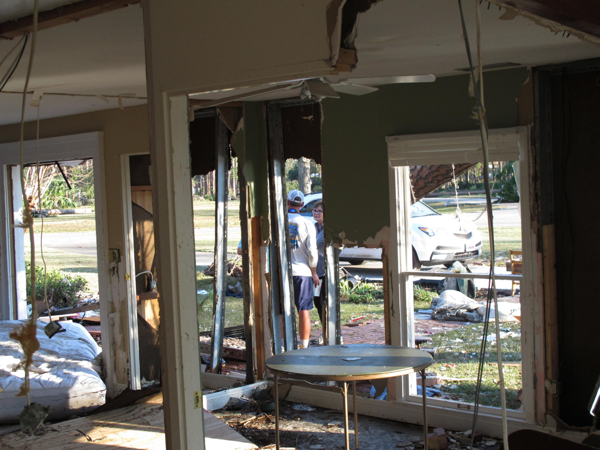 Josh and Nancy Buzzett talk Thursday, Oct. 11, 2018, outside the family’s home in Port St. Joe, Fla., a day after it was gutted by a storm surge from Hurricane Michael. The powerful storm wrecked several homes overlooking the Gulf of Mexico in Port St. Joe, but largely spared the neighboring coastal community of Apalachicola. (AP Photo/Russ Bynum)